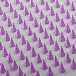 angled view from above of dozens of sharp purple pyramids laid out in a grid on a gray base